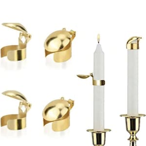 Peut inclure: Quatre éteignoirs de bougie dorés avec un couvercle à charnière. Les capuchons sont conçus pour s'adapter autour d'une bougie et éteindre la flamme. Deux bougies sont montrées sur l'image, l'une avec un éteignoir de bougie et l'autre avec un éteignoir de bougie éteint.