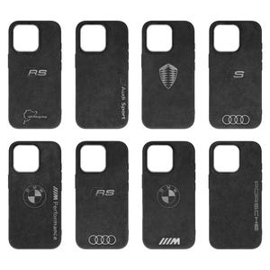 May include: Nine different phone cases featuring various logos and branding. The cases are black with a suede-like texture. The logos include Audi Sport, RS, S, BMW Performance, and Porsche.