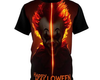 May include: A black short-sleeve t-shirt featuring a graphic print of a clown face with orange hair and makeup, bisected by a vertical glowing orange line. The text "HAPPY HALLOWEEN" is printed in orange at the bottom of the shirt.