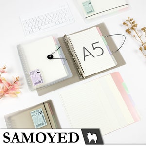 May include: A5 size binder notebooks with lined paper and coloured dividers. The notebooks are in clear plastic covers and feature a black elastic closure. The brand name "SAMOYED" is displayed at the bottom of the image.