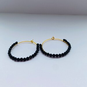 medium beaded hoop earrings. black beads hand stitched on to hoop.  golden and stainless steel color beading hoop earrings. boho hoops. gift