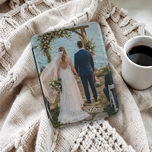 May include: A rectangular photo print showing a wedding scene with a bride and groom holding hands. The date "03.04.2025" is visible. The print is on a beige knitted blanket, next to a white mug filled with coffee.