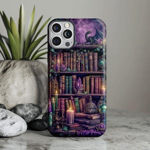 iPhone case with dragon perched on a bookshelf amidst books, crystals, and candles.