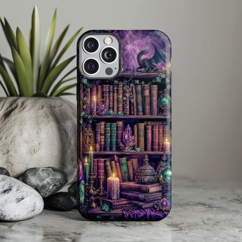 iPhone case with dragon perched on a bookshelf amidst books, crystals, and candles.