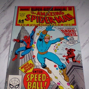 Puede incluir: Una portada de cómic con Spider-Man, Daredevil y Speedball. La portada es roja, azul y amarilla con el título "The Amazing Spider-Man" y "The Evolutionary War".