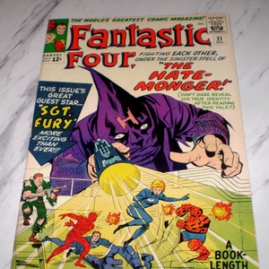 May include: A comic book cover featuring the Fantastic Four fighting the Hate-Monger. The cover is purple, green, and yellow with the title "Fantastic Four" in large, bold letters. The text "Fighting Each Other, Under The Sinister Spell Of "The Hate-Monger!" is also featured on the cover.