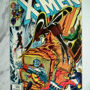 May include: A Marvel Comics Group X-Men comic book, issue 108, titled Armageddon Now! The cover features a colorful illustration of X-Men characters in action, including Storm, Colossus, and Cyclops, with a large golden mechanical structure.