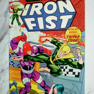 May include: A Marvel Premiere Iron Fist comic book, issue 18, featuring a colorful cover illustration of Iron Fist in a green suit fighting a purple-clad character, with a woman in the foreground and bold text including Martial Arts Mayhem.