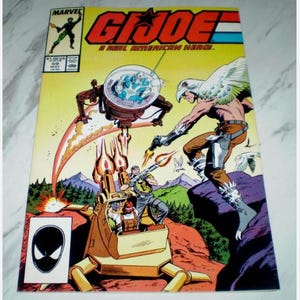 May include: A vintage G.I. Joe comic book cover featuring action-packed illustrations. The cover displays the title "G.I. Joe: A Real American Hero" with characters in combat. The comic book has a Marvel logo and issue number 59.