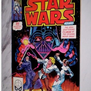 May include: A vintage Star Wars comic book cover. The title "STAR WARS" is in large red and yellow letters. The cover features Darth Vader, Luke Skywalker, Princess Leia, and Obi-Wan Kenobi in a space fantasy scene. The comic is a Marvel Movie Showcase.
