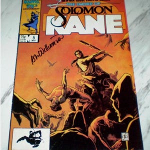 Puede incluir: Portada de cómic vintage de "The Sword of Solomon Kane" #5, una serie limitada de seis números. La portada presenta una ilustración dinámica con figuras en acción sobre un fondo naranja. Incluye el logotipo de Marvel Comics y el texto "75c" y "May".