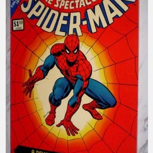 Puede incluir: Una portada de cómic vintage con Spider-Man en una pose dinámica sobre un fondo de telaraña roja. El título "The Spectacular Spider-Man" se muestra de forma destacada. La portada también incluye el texto "Marvel Treasury Edition" y "A Deluxe Limited Edition of The World's Greatest Superhero."