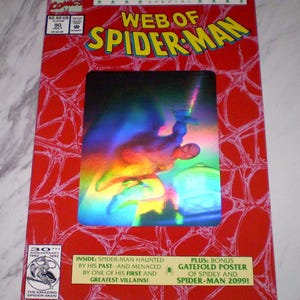 Peut inclure: Une bande dessinée "Web of Spider-Man" avec une couverture rouge présentant une image holographique de Spider-Man. La couverture comprend le logo Marvel Comics, les détails de l'édition et un texte indiquant un numéro spécial du 30e anniversaire. Du texte supplémentaire décrit le contenu.