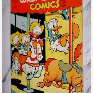 May include: Vintage Walt Disney's Comics comic book cover. The cover features Donald Duck and his nephews riding a carousel. The title is in large, colorful letters against a red background. The comic is dated April and priced at 10 cents.
