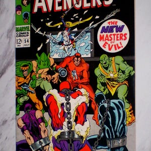 May include: A vintage comic book cover for "The Avengers" featuring a group of costumed heroes and villains. The title is in large red and white letters. The cover includes the text "The New Masters of Evil!" and "Marvel Comics Group".