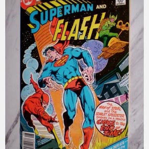 May include: A vintage comic book cover featuring Superman and Flash. Superman, in a blue suit with a red cape, is depicted in action alongside the Flash in a red suit. The cover has the text "DC Comics Presents" and "Superman and Flash".