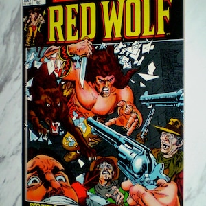 May include: A vintage Red Wolf comic book issue number 1 from Marvel Comics Group, dated May. The cover features a central illustration of a character with a wolf, wielding a knife amidst shattered glass, with guns pointed and text reading Red Wolf.