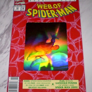 May include: A comic book cover for "Web of Spider-Man" featuring a red background with a spiderweb design. The title is in yellow and green. The cover includes a holographic image of Spider-Man and text that reads "Giant-Sized 30th Anniversary Special".