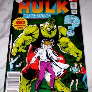 Puede incluir: Una portada de cómic de "The Incredible Hulk" presenta una gran figura verde de Hulk que se alza sobre un hombre con bata blanca y pantalones morados. La portada incluye el texto "The Strangest Man of All Time!!" y "Is He Man or Monster or... Is He Both?"