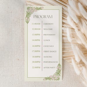 May include: A cream-coloured rectangular program card with floral corner designs. The card details an event schedule, including ceremony, welcome, photoshoot, lunch, cocktails, first dance, dancing, performances, and after party.