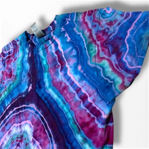 May include: A tie-dye t-shirt with a blue, purple, pink, and green swirl pattern.
