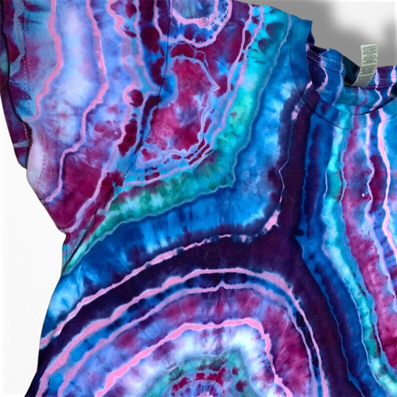 May include: A tie-dye t-shirt with a blue, purple, pink, and green agate pattern.