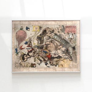 Puede incluir: Un rompecabezas enmarcado que presenta un mapa de dibujos animados políticos antiguos de Europa. La obra de arte incluye un globo aerostático con el texto "EUROPE COMIC", un sol y la palabra "RUSSIE" en un sombrero. El rompecabezas está en un marco plateado.