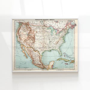 May include: A framed vintage map of the United States and Mexico, with detailed geographical information. The map is in a rectangular frame with a white border. The map's colors include shades of brown, green, and blue, with text in German.