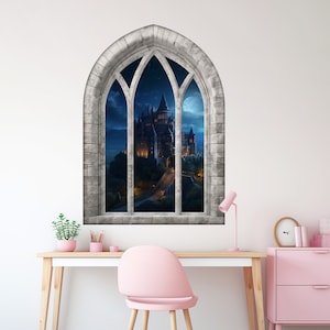 Puede incluir: Un vinilo decorativo de pared con una ventana gótica arqueada que muestra un castillo de noche. El marco de la ventana es de piedra gris, y el castillo está iluminado con luces cálidas. Un escritorio y una silla están delante.