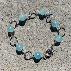 Iridescent blue glass bead and silver ring bracelet