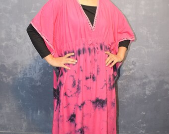 May include: A pink and black tie-dye kaftan with a V-neck and a drawstring waist. The kaftan has a lace trim around the neckline and sleeves.