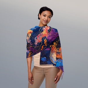 May include: A woman wearing a blue, purple and orange scarf with a jellyfish print. The scarf is made of a soft, flowing fabric and has a fringed edge.