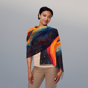 May include: A woman wearing a blue, orange, and yellow patterned scarf with a fringed edge. The scarf has a design of abstract waves and dots.