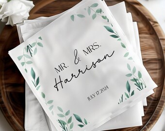 May include: White napkins with a green leafy design and the text "MR. & MRS. Harrison JULY 17, 2024" printed on them.