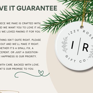 The image is a promotional image for a company called "Izzy Rose Gift Co.", featuring a white ornament with a floral design hanging from a branch. The text on the ornament reads "Izzy Rose Gift Co. - I love it guarantee" and includes a message about the company's commitment to making each piece with care and prioritizing the recipient's happiness.