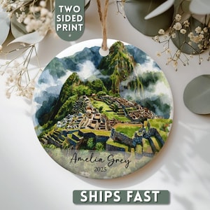 Puede incluir: Adorno redondo con impresión a doble cara que representa Machu Picchu en acuarela. El adorno tiene una cuerda para colgar y el texto "Amelia Grey 2025". La imagen muestra la antigua ciudad enclavada en las montañas.