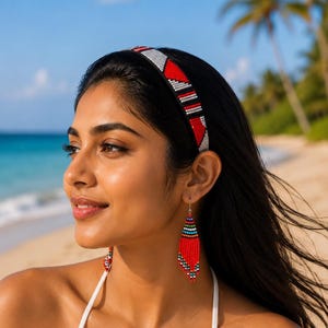 May include: A headband featuring a geometric pattern of red, black, and silver beads, paired with long, triangular drop earrings crafted from rows of red, blue, green, and white seed beads that taper to a point at the bottom of each earring.