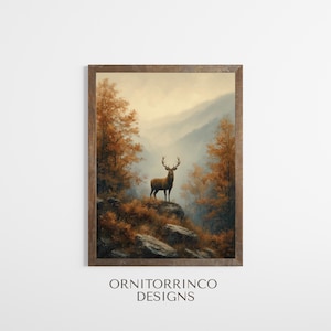 May include: A framed print featuring a majestic deer with large antlers standing on a rocky outcrop. The artwork depicts a mountainous landscape with autumn foliage in shades of orange and brown. The text "ORNITORRINCO DESIGNS" is at the bottom.