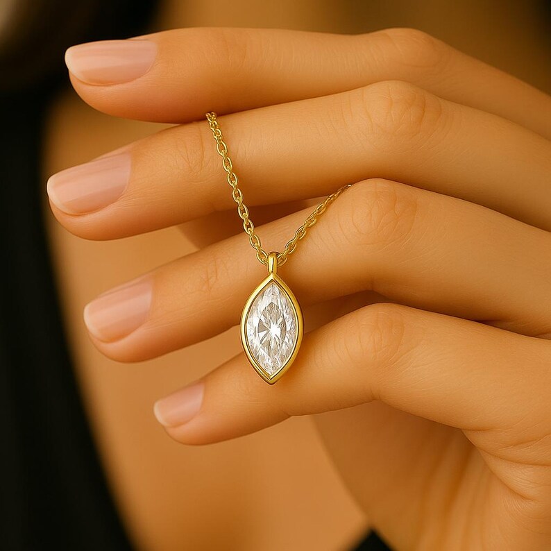 May include: A gold chain necklace with a marquise-shaped diamond pendant.