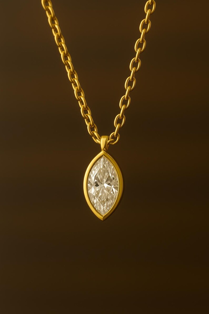 May include: A gold chain necklace with a marquise-shaped diamond pendant.