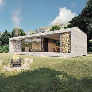 Può includere: Una casa moderna a un piano con un esterno in cemento e grandi finestre. La casa ha un ponte in legno e un focolare di fronte ad essa.