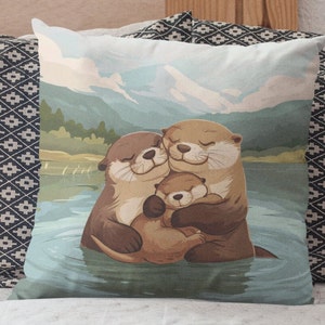 May include: A throw pillow with a cute illustration of three otters swimming in a lake. The otters are brown and have white bellies. The background is a blue lake with green trees and mountains in the distance.
