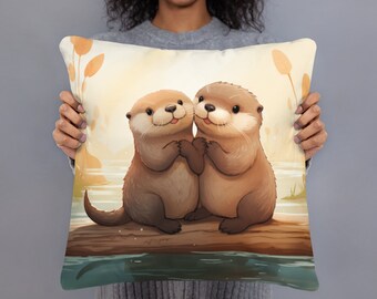 May include: A decorative throw pillow featuring a cartoon illustration of two otters hugging on a log in a lake. The otters are brown and have big eyes and smiles. The background is a soft yellow with green reeds.