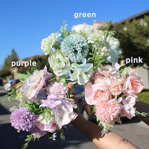 May include: Three bouquets of artificial flowers in shades of purple, green, and pink. The bouquets include roses, hydrangeas, and other floral arrangements. The word "purple", "green", and "pink" are written above each bouquet.