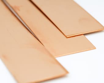 May include: Three rectangular sheets of copper metal stacked on top of each other. The sheets are a light orange-brown color.