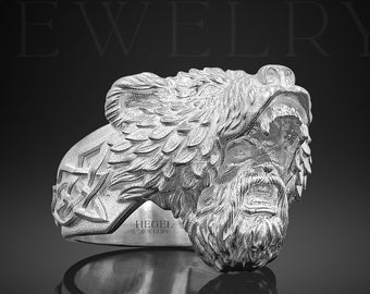 May include: A silver ring with a detailed bear head design. The bear's mouth is open and its teeth are visible. The ring is engraved with the words "HEGEL JEWELRY".
