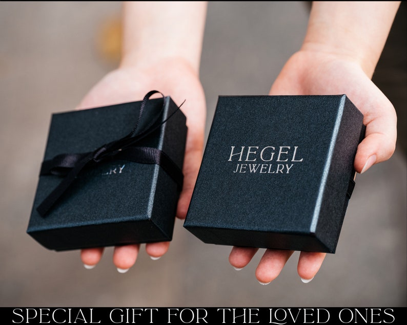 May include: Two black gift boxes with black ribbon. The larger box has the text "HEGEL JEWELRY" printed on the top.