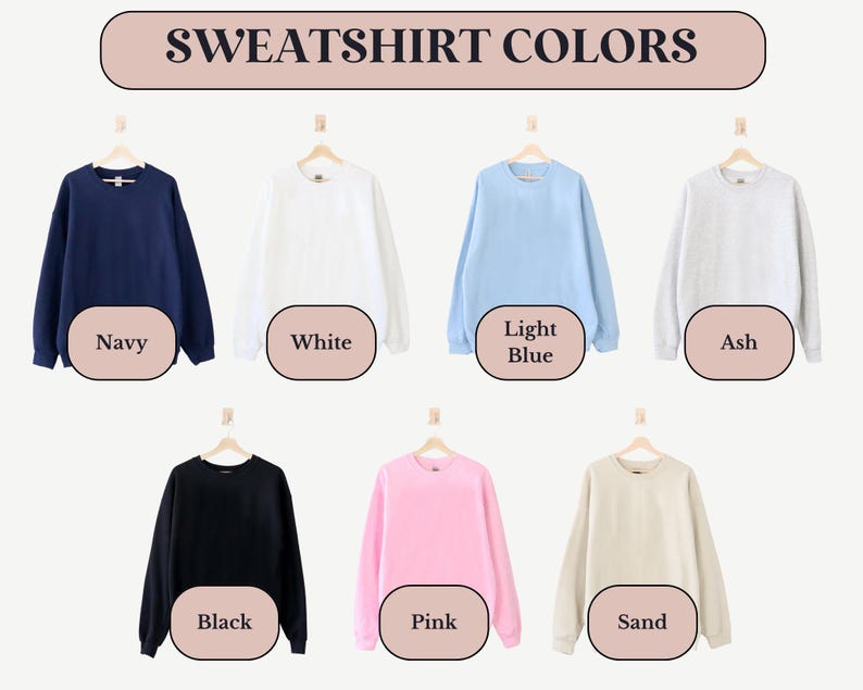 May include: A display of eight sweatshirts in different colors, including navy, white, light blue, ash, black, pink, and sand. The sweatshirts are hanging on hangers against a white background. The text "SWEATSHIRT COLORS" is displayed above the sweatshirts.