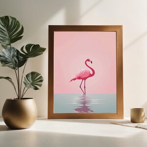 Puede incluir: Una impresión enmarcada de un flamenco rosado de pie en un cuerpo de agua. El fondo es de color rosa claro.