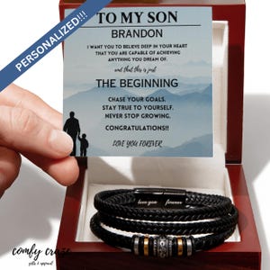 Puede incluir: Una caja de madera con un brazalete de cuero negro en su interior. La caja tiene un mensaje personalizado que dice "To My Son Brandon I Want You To Believe Deep In Your Heart That You Are Capable Of Achieving Anything You Dream Of. And That This Is Just The Beginning Chase Your Goals. Stay True To Yourself. Never Stop Growing. Congratulations!! Love You Forever".